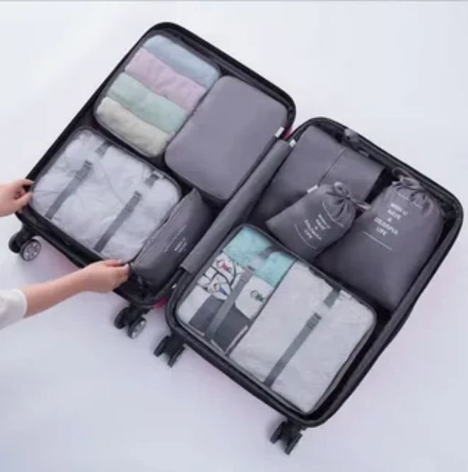Essential items packed in a bag for comfortable train travel including phone charger and water bottle.
