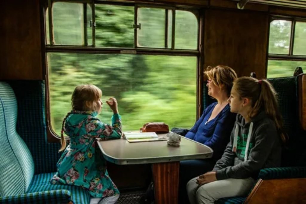 A happy family sitting together inside a train compartment.
