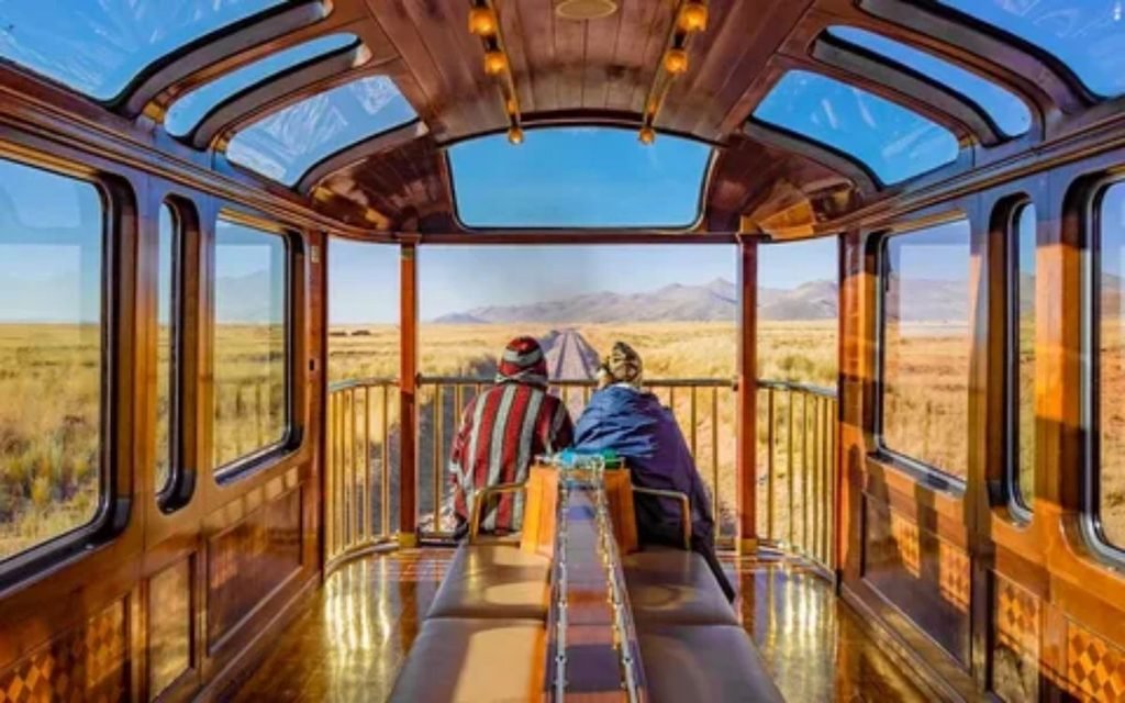 Passengers enjoying scenic views through large windows on an Alaska train journey