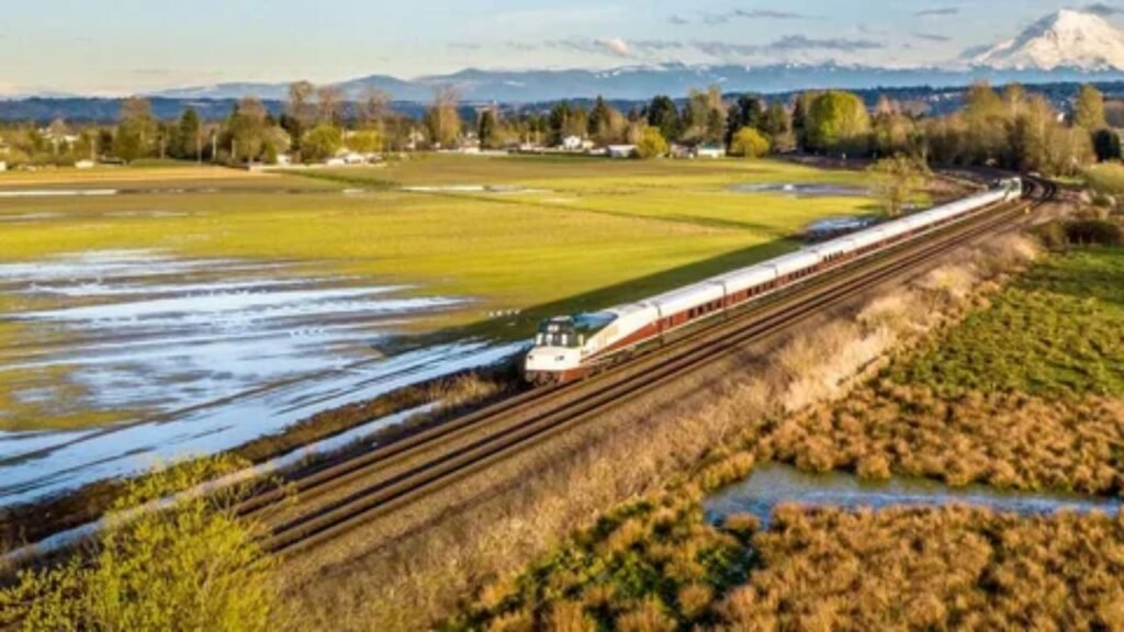 Amtrak passenger train traveling through scenic American countryside.