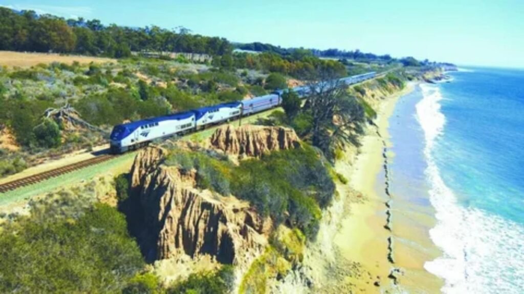 Amtrak Superliner passenger train traveling through scenic mountain landscape in North America.