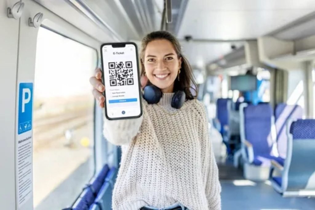 Traveler showing a digital railcard and train ticket on a smartphone