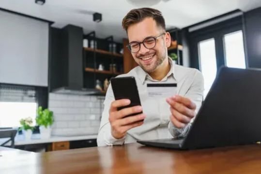 Traveler planning a journey on a laptop while comparing affordable train fares