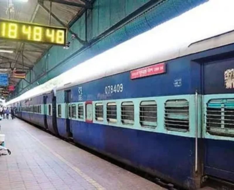 Passengers waiting on a modern railway station platform with departure boards.