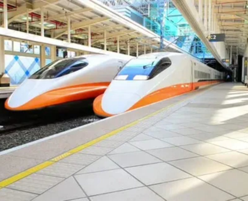 High-speed bullet train passing through a modern railway station.