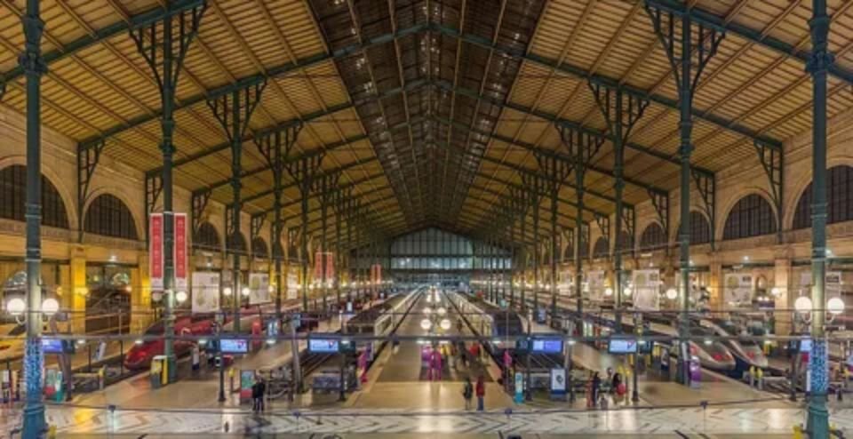 Passengers walking through a busy European railway station with departure boards