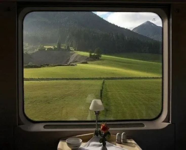 Passenger window view of Tuscan hills and vineyards from an Italian train
