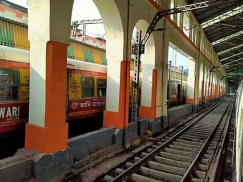 : Busy modern railway station platform with departure screens.