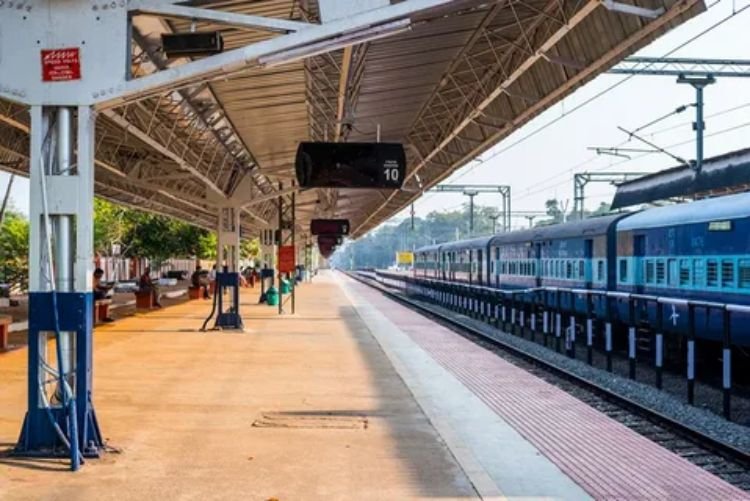 A traveler with luggage waiting on a train station platform