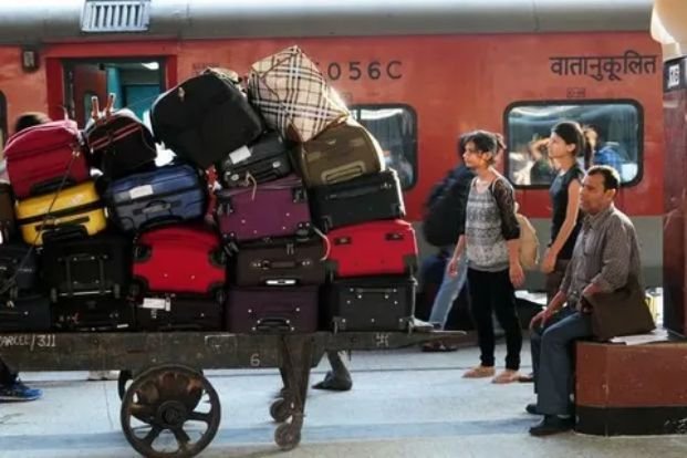 Passengers with luggage boarding a train at railway platform early