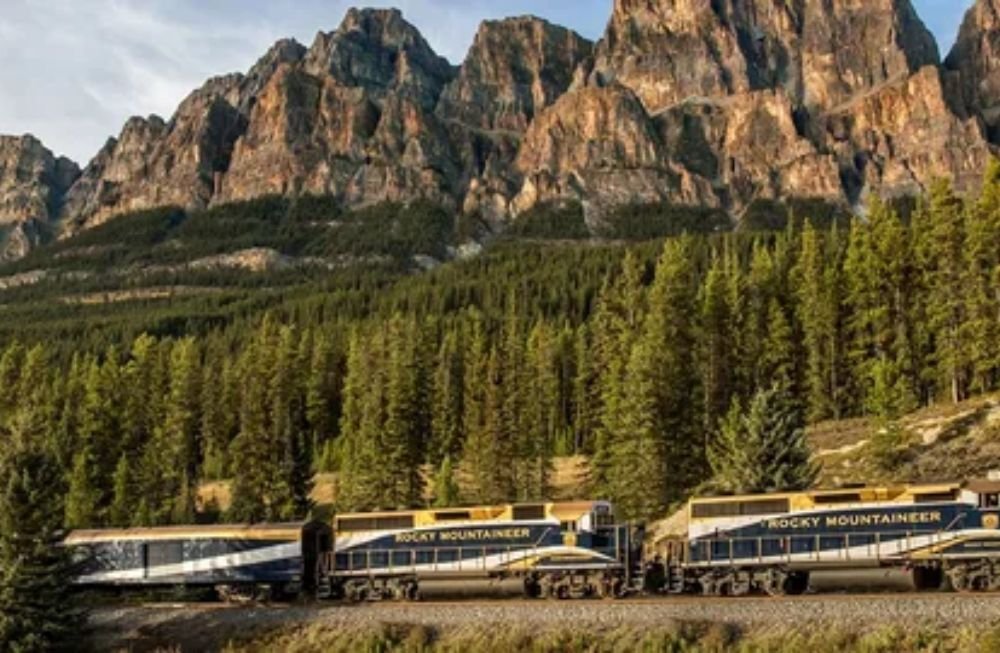 Rocky Mountaineer train traveling through the scenic Canadian Rockies with glass-dome windows