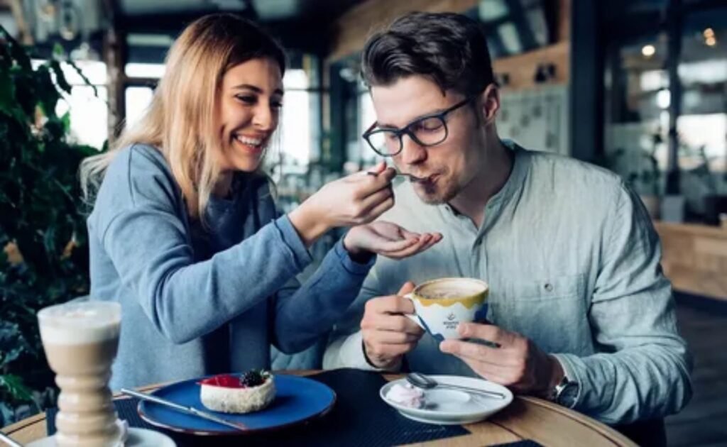 Couple sharing a coffee in a train dining car during a romantic getaway