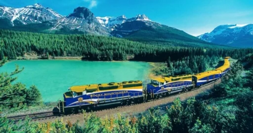 Scenic Rocky Mountaineer luxury train passing through Canadian Rockies with snow-capped mountains and river