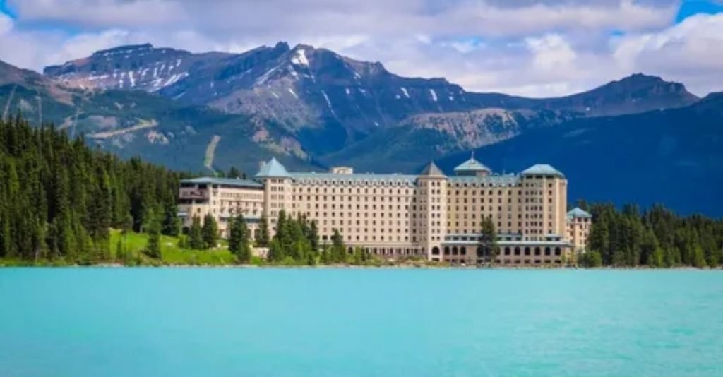 Exterior view of Fairmont Banff Springs historic hotel set against mountain forest in Banff