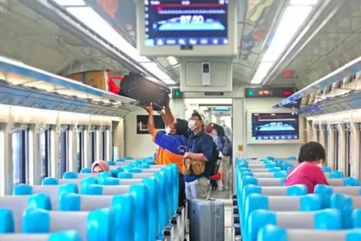 Different types of train passengers relaxing inside a modern intercity train carriage
