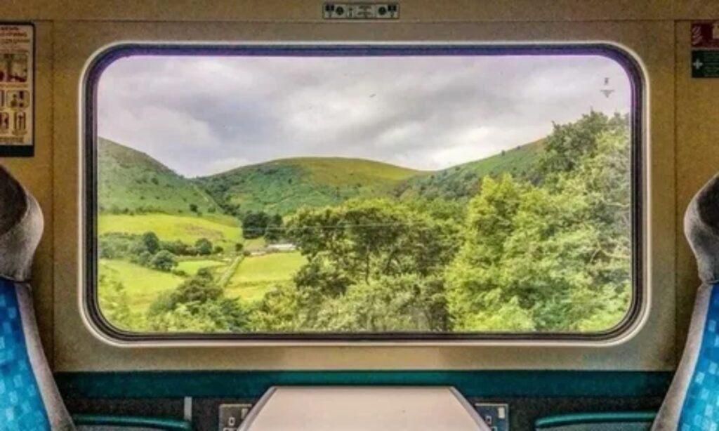 Passenger in train enjoying a comfortable journey through a scenic landscape