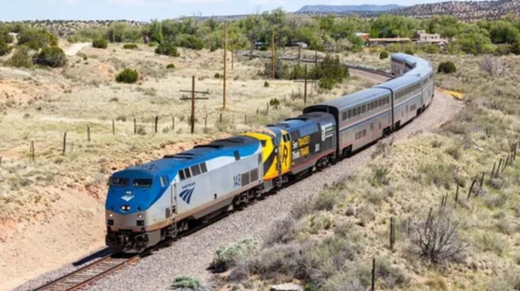 Amtrak passenger train traveling through scenic mountain landscape in USA